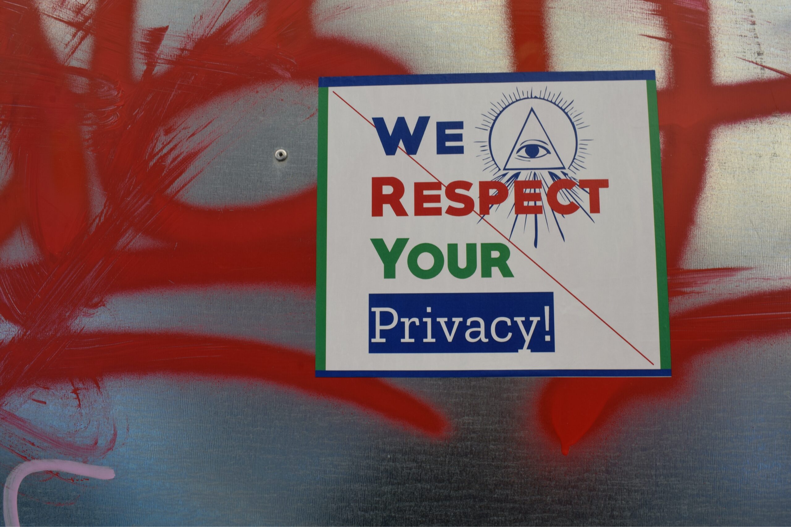 A sticker that reads "We respect your privacy" is placed on top of red graffiti