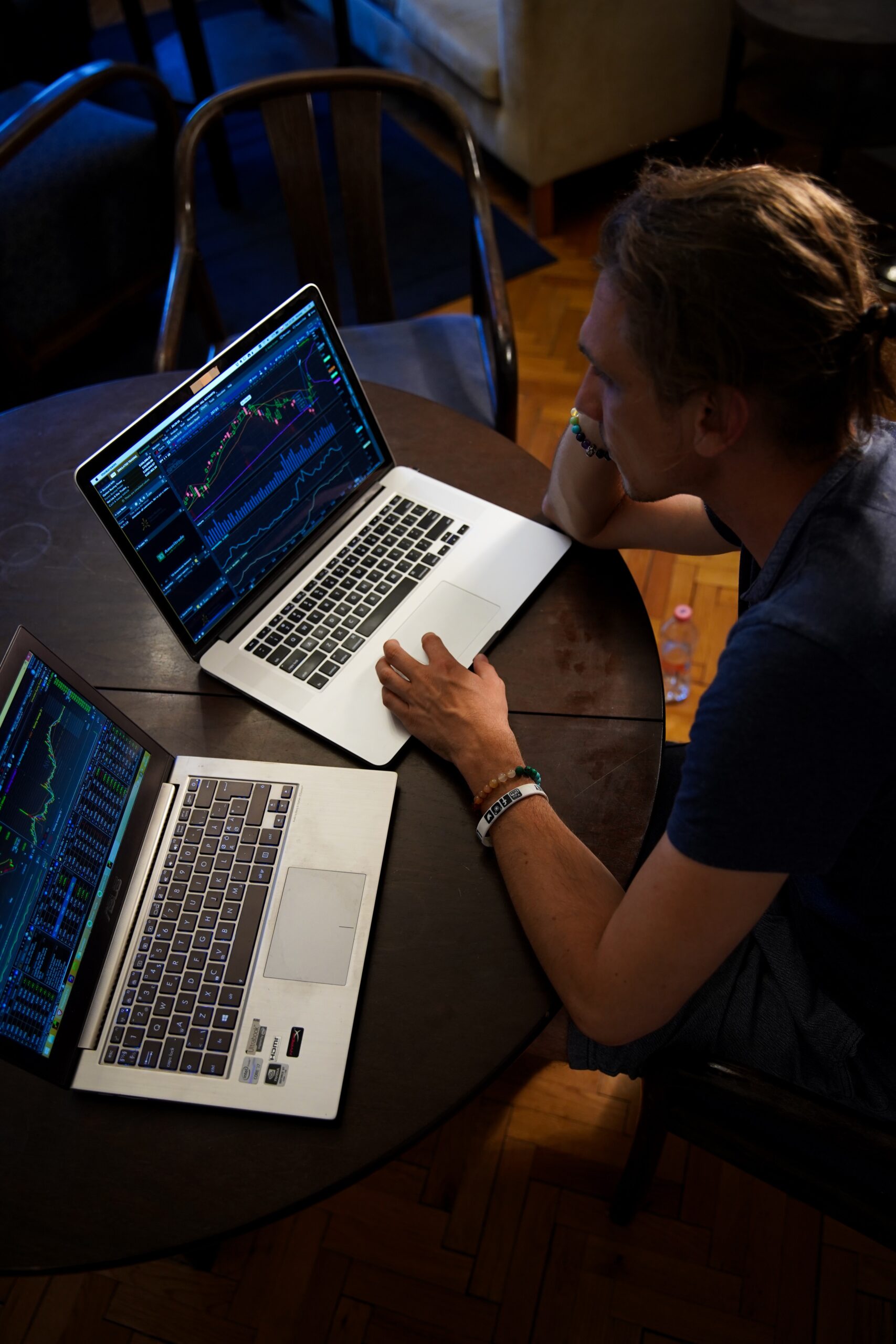 A man looking at two computer screens worth of consumer data.